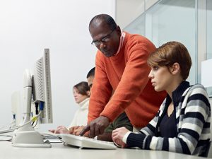 A teacher helping a student in a CTE program 